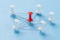 Network with red and white pins and string, An arrangement of colorful pins linked together with string on a blue background Royalty Free Stock Photo