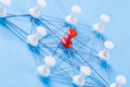 Network with red and white pins and string, An arrangement of colorful pins linked together with string on a blue background Royalty Free Stock Photo