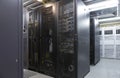 Network server room with parallel rows of mainframe. Corridor in big working data center full of rack servers and supercomputers