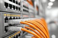 Network switch with connected orange ethernet cables and active status lights in a data center rack showcasing modern network Royalty Free Stock Photo