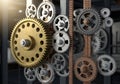 A network of variously sized gears, featuring metallic and bronze tones, is interconnected in a Royalty Free Stock Photo