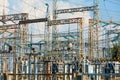 A network of wires with metal masts and high voltage dielectric insulators against a blue cloudy sky on a sunny day Royalty Free Stock Photo