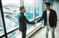 Networking, a powerful business tool. two young businessmen shaking hands in a modern office. Royalty Free Stock Photo