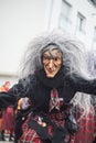 portrait of people with wooden mask and witch costumes parading in the street