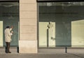 A senior looks curiously through a shop window