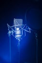 Neumann TLM 102 studio recording microphone with a spotlight on it