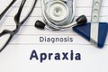 Neurological diagnosis of Apraxia. Neurological hammer, stethoscope and doctor`s glasses lie on doctor workplace on sheet of noteb Royalty Free Stock Photo