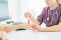 Neurological examination. The neurologist testing hand reflexes on a female patient using a hammer. Diagnostic, healthcare,