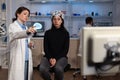 Neurologist doctor showing monitor with brain activity to woman patient with eeg scanner