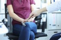 Neurologist examines patient and taps leg with hammer closeup