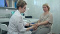 Neurologist testing knee reflex on a female patient using a hammer Royalty Free Stock Photo