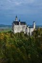 Neuschwanstein castle on Alps background in vicinity of Munich, Bavaria, Germany, Europe. Autumn landscape with castle Royalty Free Stock Photo