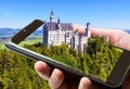 Neuschwanstein castle in Bavaria, Germany. Taking picture of fairytale castle by mobile or cell phone, photo of landscape