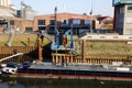 View on old historic inland loading port landing pier with vessel on rhine river, cranes and factories