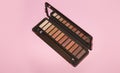 neutral brown eye shadow palette on pink background. Female decorative cosmetics. Close up