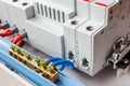 Neutral bus connected by blue wires closeup against automatic circuit breakers in the white plastic mounting box Royalty Free Stock Photo