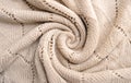 Neutral color knitted fabric texture. Product from wool. Handwork , Folded in waves and folds textiles. Detailed warm yarn