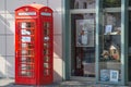 Neuwied, Germany - April 8, 2020: a british phone box in front of a facade of a modern building with a showcase