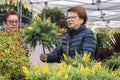 Two female customers are interested in plants offered at the local spring garden market