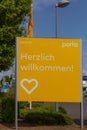 Billboard with `Herzlich willkommen` welcome in front of the parking area of the Porta furniture store.
