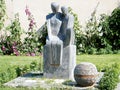 Neve Monosson sculpture on a background of hollyhocks 2011