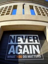 Never Again poster on corner of museum wall Royalty Free Stock Photo