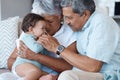 They never do well with goodbyes. grandparents bonding with their grandchild on a sofa at home.