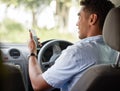 He never gets lost while going about logistics. Shot of a young delivery man using a cellphone while sitting in a van. Royalty Free Stock Photo