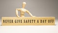 Never give safety a day off. Written on wooden surface