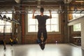 Never give up Back view of strong man doing pull-ups while exercising in the gym Royalty Free Stock Photo