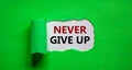 Never give up symbol. Words `Never give up` appearing behind torn green paper. Business and `never give up` concept. Copy spac