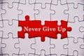 Never give up text on missing jigsaw puzzle. Motivational and inspirational concept Royalty Free Stock Photo