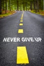 Never give up word on asphalt road surface with marking lines Royalty Free Stock Photo