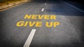 Never give up word on asphalt road surface with marking lines Royalty Free Stock Photo