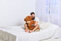 Never grow up concept. Guy on happy face hugs giant teddy bear. Macho with beard and mustache cuddling with plush toy Royalty Free Stock Photo