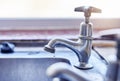 Never leave a tap dripping. two dripping taps waisting a little bit of water in a basin inside of a house during the day Royalty Free Stock Photo