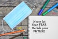 Never let your fear decide your future written on notebook