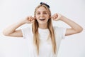 Never listen to haters and enjoy life. Portrait of good-looking happy and carefree blonde girl in headband and white