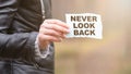 NEVER LOOK BACK concept. Text on the sheet in hand