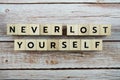 Never Lost Yourself word alphabet letters on wooden background