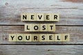 Never Lost Yourself word alphabet letters on wooden background