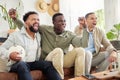 We never miss a game. Shot of three male friends watching something together while sitting on a couch. Royalty Free Stock Photo