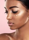 She never neglects her skin. Studio shot of a beautiful young woman posing with moisturizer on her face against a pink Royalty Free Stock Photo