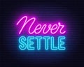 Never Settle l neon quote on a brick wall.
