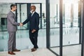 Never stop building meaningful relationships. two businessmen shaking hands in an modern office.