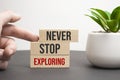 Never Stop Exploring. text on a white sheet of paper on a red notepad on the desk Royalty Free Stock Photo