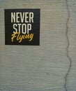 Never stop flying your dream, a quote sticker on a concreat wall Royalty Free Stock Photo