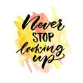 Never stop looking up. Inspirational saying. Vector handwritten quote on yellow and orange watercolor stain