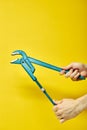 New Adjustable wrench isolated on yellow background in cropped male hands Royalty Free Stock Photo