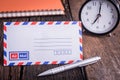 New airmail envelope and ballpoint pen with alarm clock Royalty Free Stock Photo